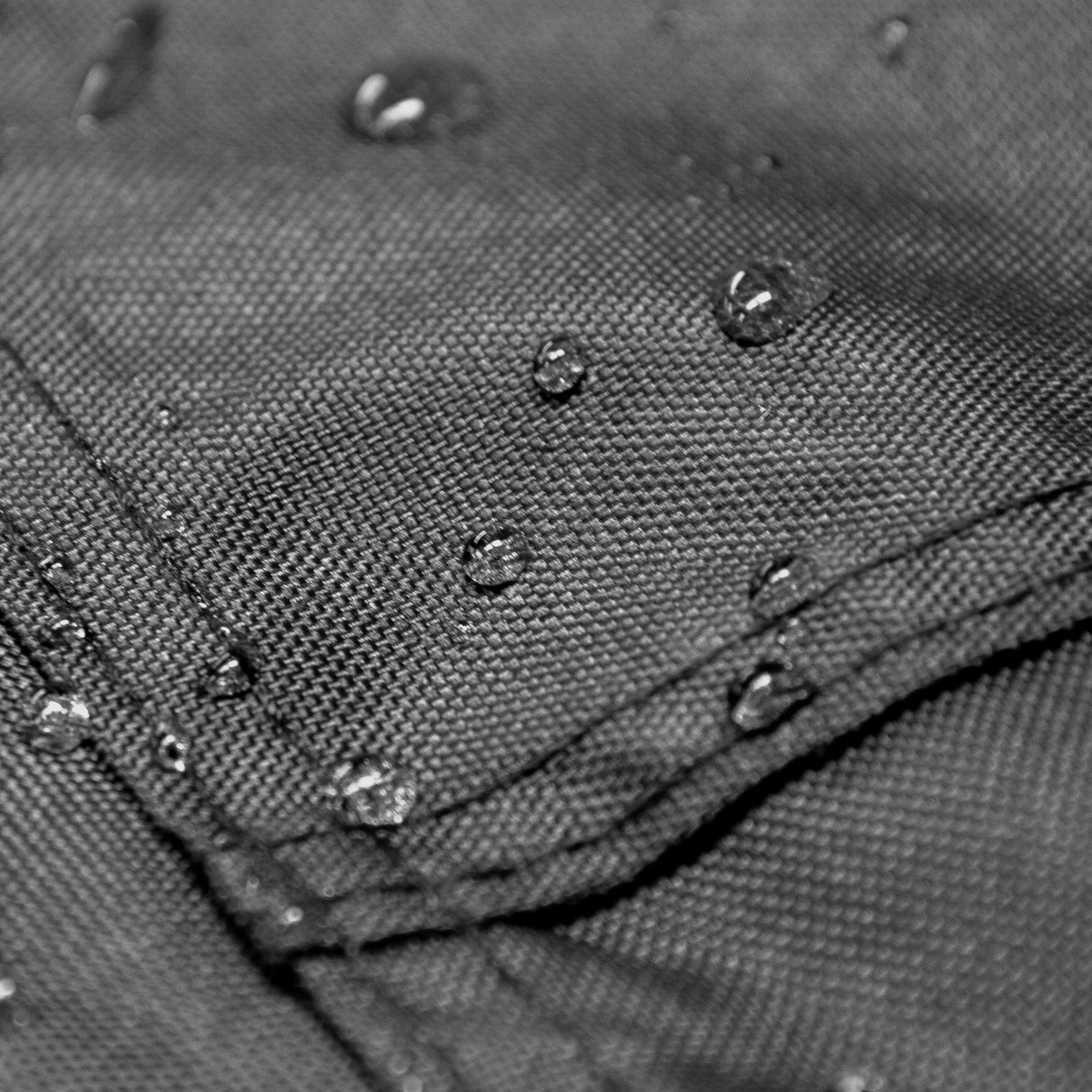 Tente de rangement XL pour moto en tissu noir imperméable, avec gouttes d'eau sur la surface, montrant sa résistance aux intempéries
