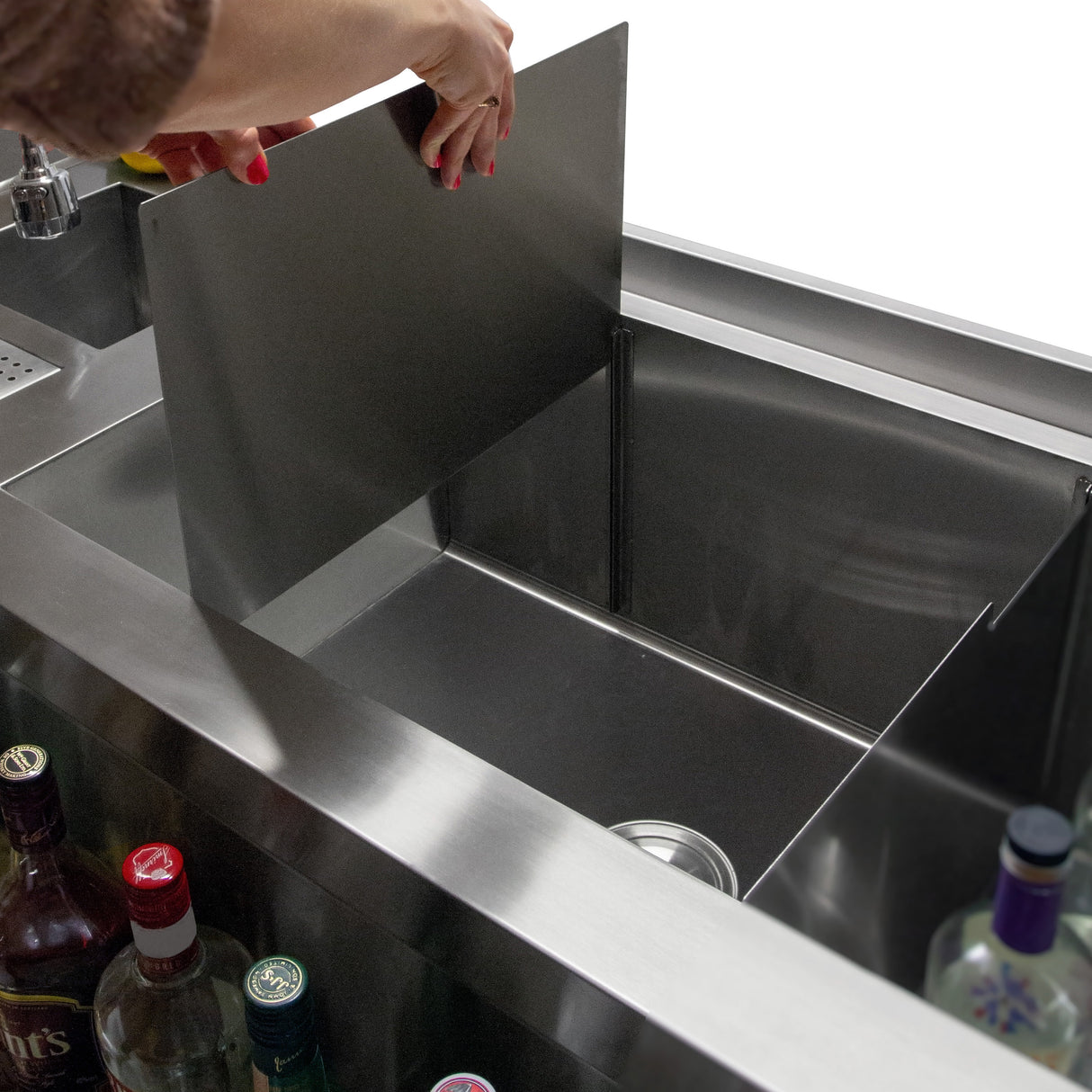 Station de bar à cocktails deluxe en acier inoxydable, avec un compartiment amovible et des bouteilles colorées en arrière-plan