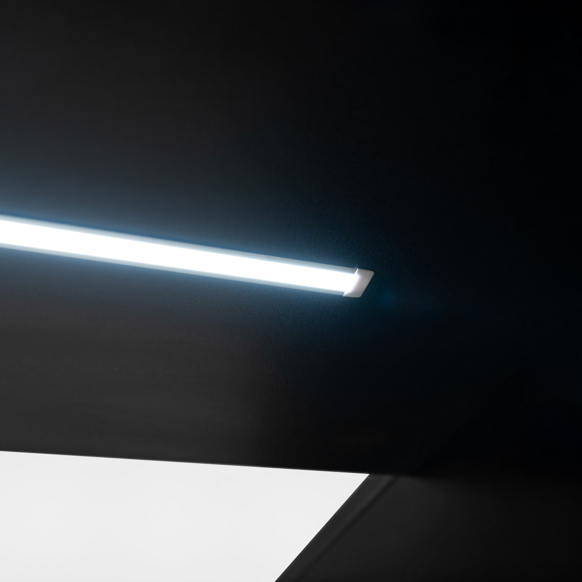 Éclairage LED moderne et élégant, avec un tube lumineux blanc sur fond noir, créant une ambiance contemporaine et minimaliste