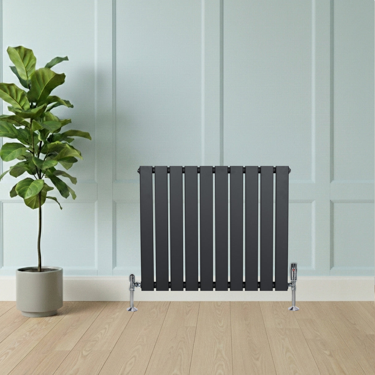 Radiateur plat à 1 panneau gris anthracite, design moderne avec vannes, installé contre un mur clair, décoré avec une plante verte