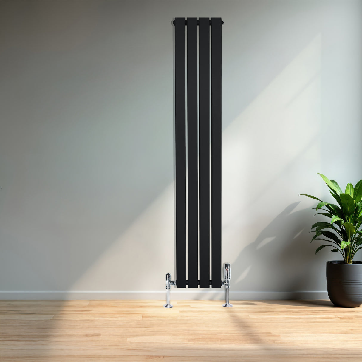 Radiateur plat noir à 1 panneau, 1600 x 280 mm, avec vannes, installé sur un mur clair, entouré d'une plante verte en pot