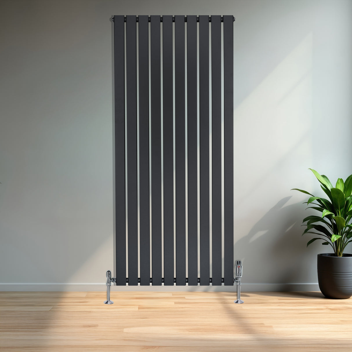 Radiateur plat à 1 panneau gris anthracite, 1600 x 700 mm, avec vannes, installé dans un intérieur moderne et lumineux