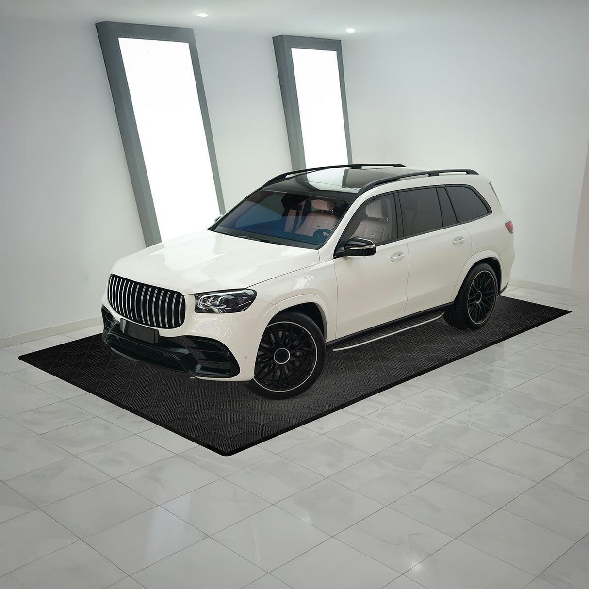 Carrelage de sol ventilé noir pour garage, avec motif en relief, entourant un SUV blanc sur un sol en carrelage brillant