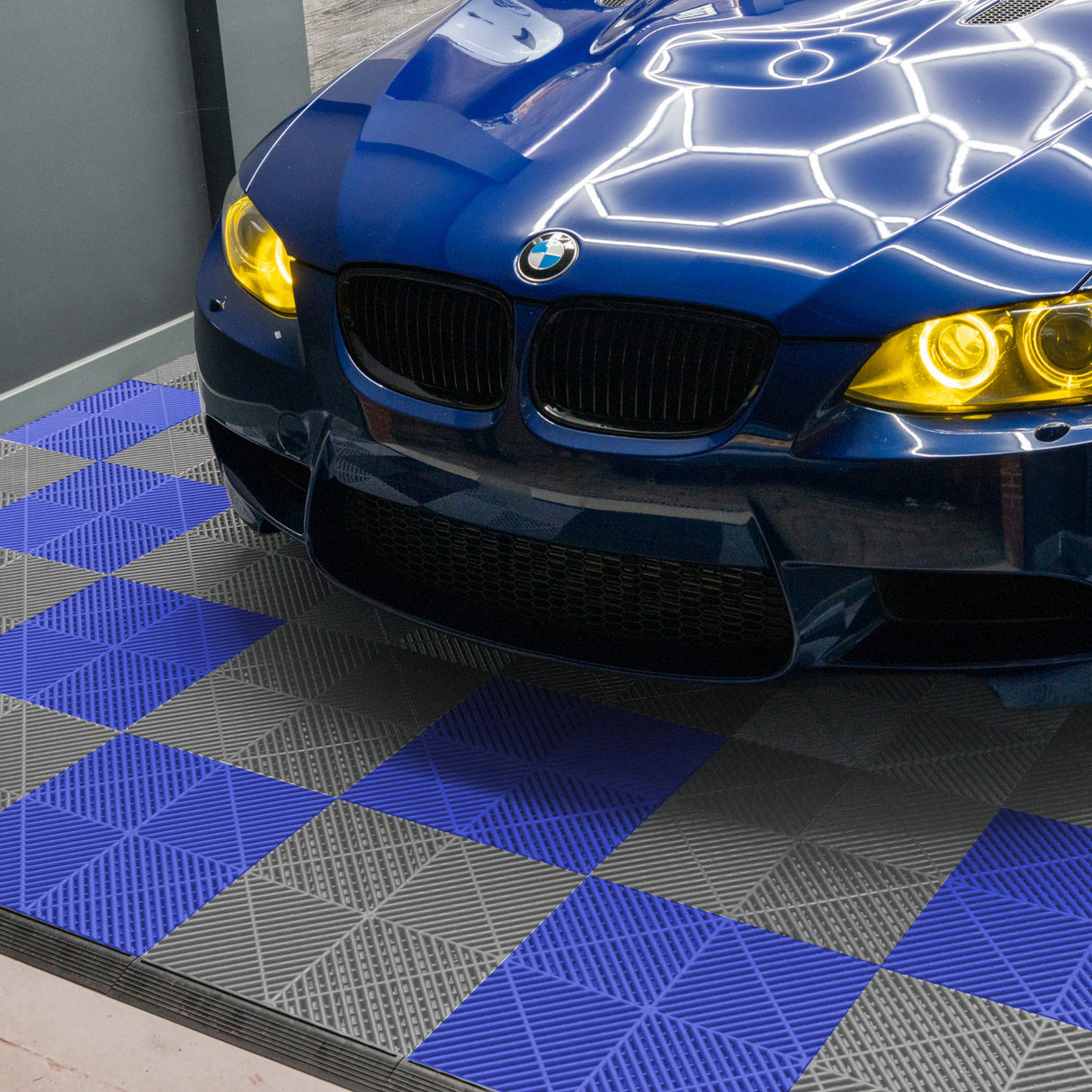 Carrelage de sol ventilé pour garage, avec motifs en bleu et gris, offrant une texture antidérapante et un design moderne