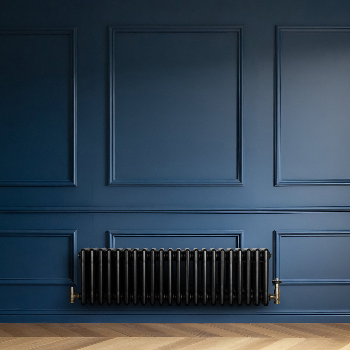 Radiateur traditionnel noir à 4 colonnes, 300 x 1010 mm, installé contre un mur bleu, avec des détails en laiton et un sol en bois clair