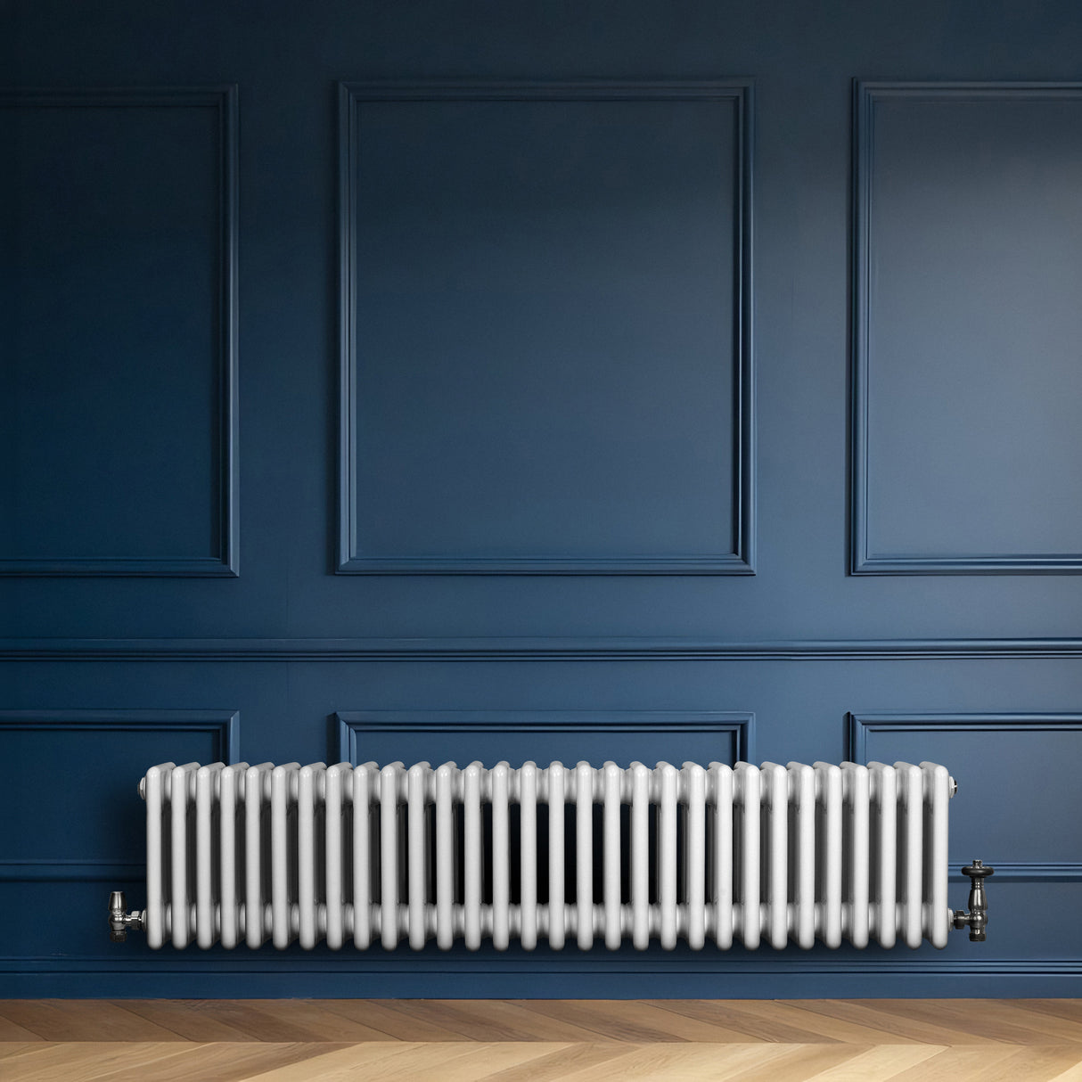 Radiateur traditionnel à 4 colonnes blanc, installé contre un mur bleu, avec un sol en parquet clair, offrant une esthétique élégante et classique
