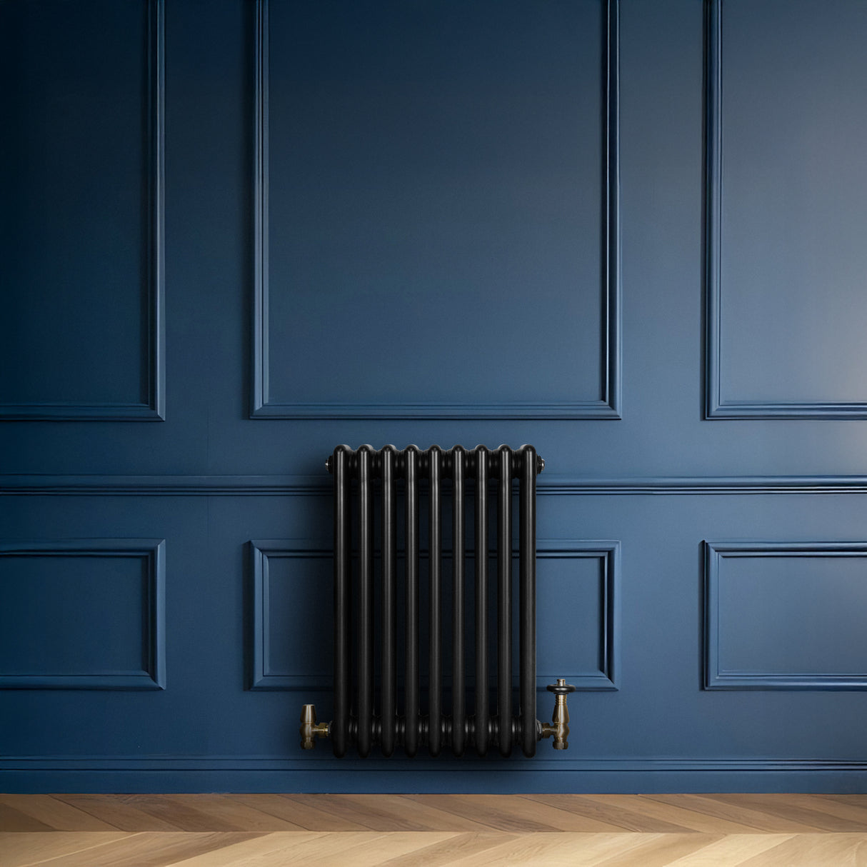 Radiateur traditionnel noir à 4 colonnes, finition lisse, installé sur un mur bleu, ajoutant une touche élégante à l'intérieur