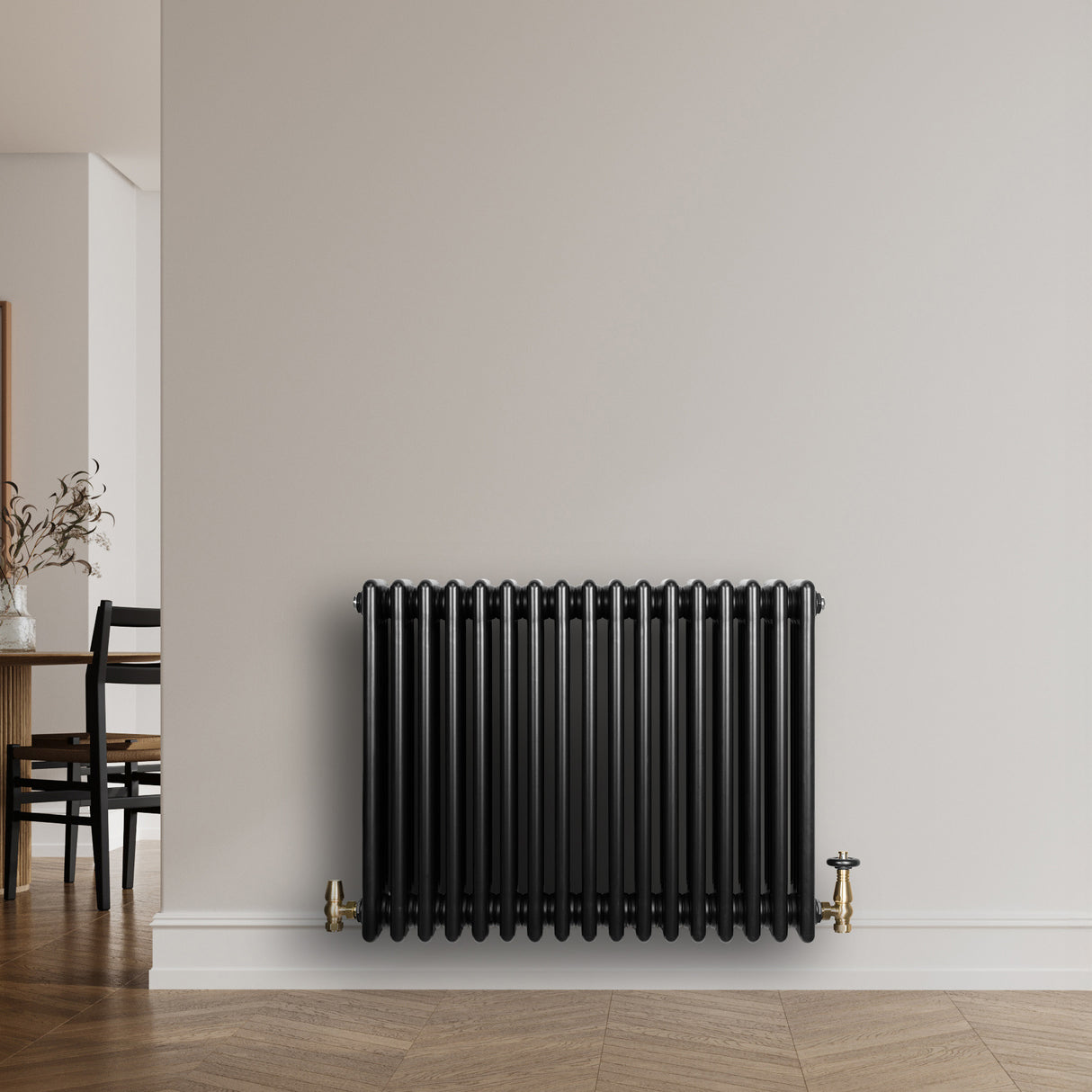Radiateur traditionnel noir à 4 colonnes, 600 x 785 mm, installé contre un mur, avec des robinets en laiton et un sol en bois clair