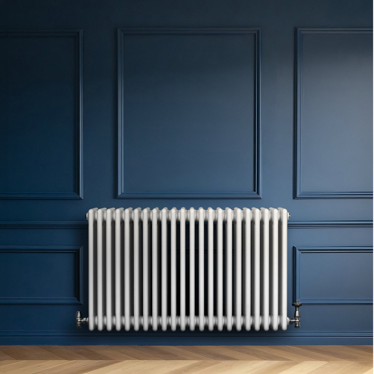 Radiateur traditionnel à 4 colonnes en blanc, installé sur un mur bleu, avec des lignes épurées et une finition lisse