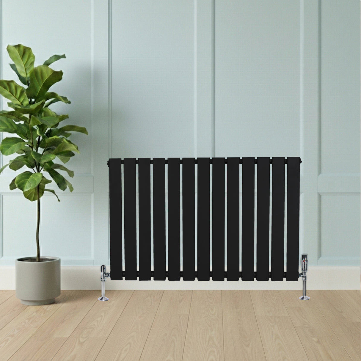 Radiateur plat noir à 1 panneau, 600 x 910 mm, avec finition lisse, installé contre un mur clair, à côté d'une plante verte en pot