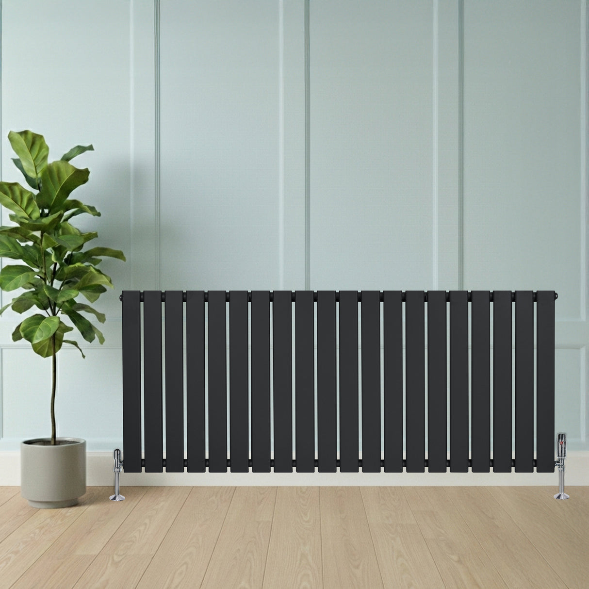 Radiateur plat à un panneau gris anthracite, 600 x 1400 mm, installé près d'une plante verte dans un intérieur moderne et lumineux