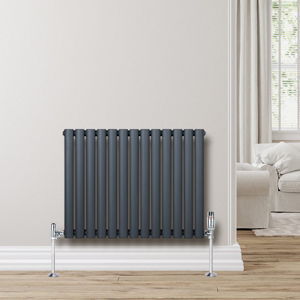 Radiateur à colonnes ovales gris anthracite, 1 panneau, 600 x 780 mm, installé contre un mur clair avec un sol en bois naturel