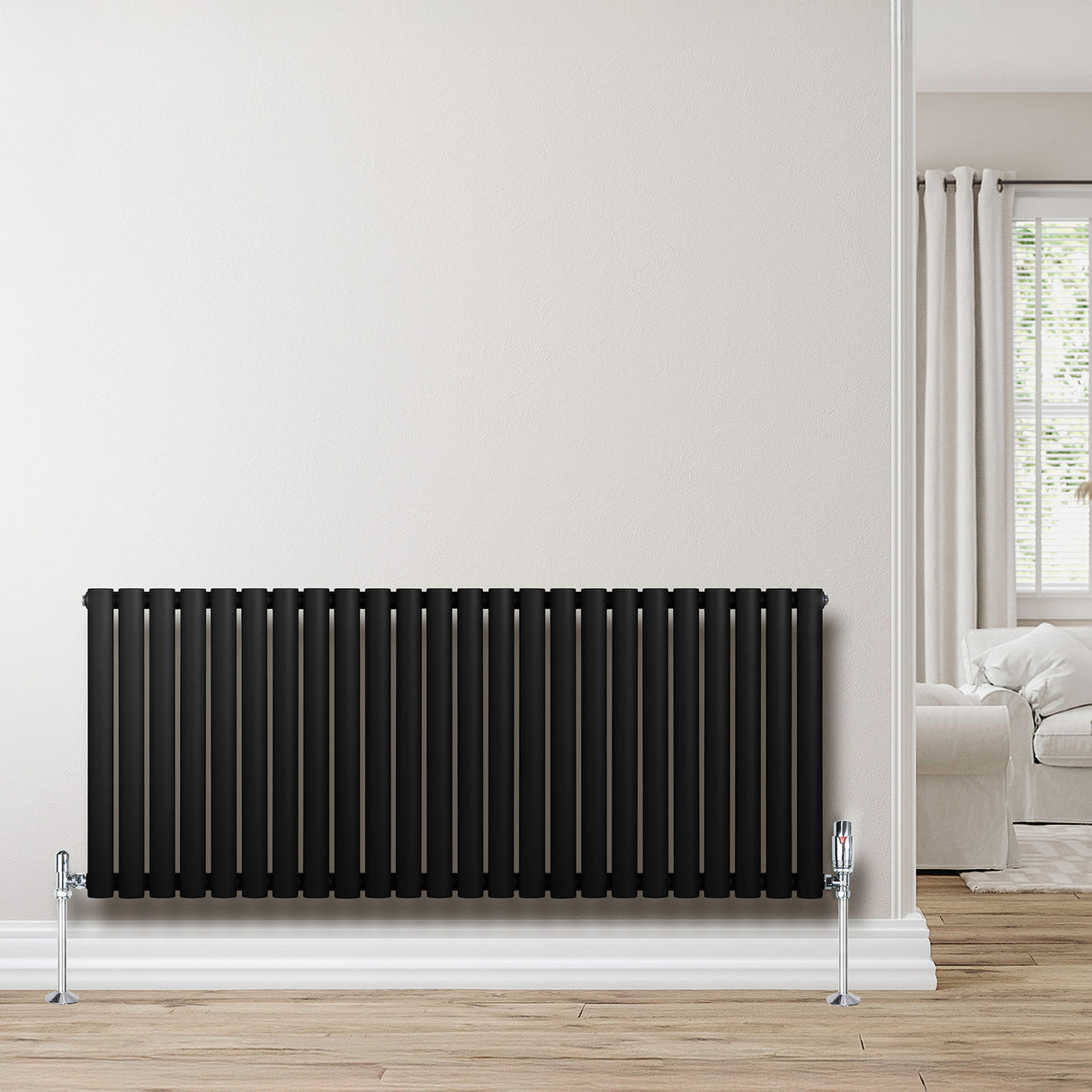Radiateur à colonnes ovales noir, 600 x 1440 mm, avec finition lisse et moderne, installé contre un mur clair dans un intérieur lumineux