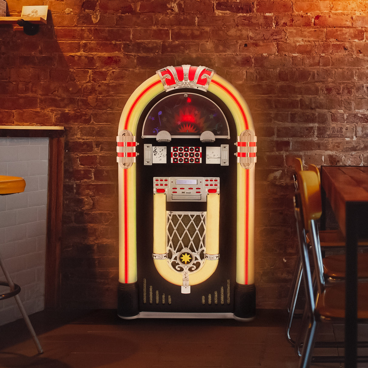 Juke-box rétro coloré avec éclairage néon, touches vintage et porte-CD, se tenant contre un mur en briques dans un café chaleureux