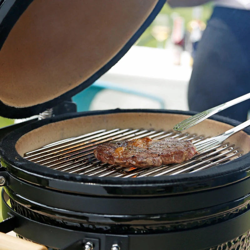 Barbecue au charbon de bois Kamado noir de 53,3 cm avec steak grillé sur grilles en acier inoxydable, couvercle ouvert