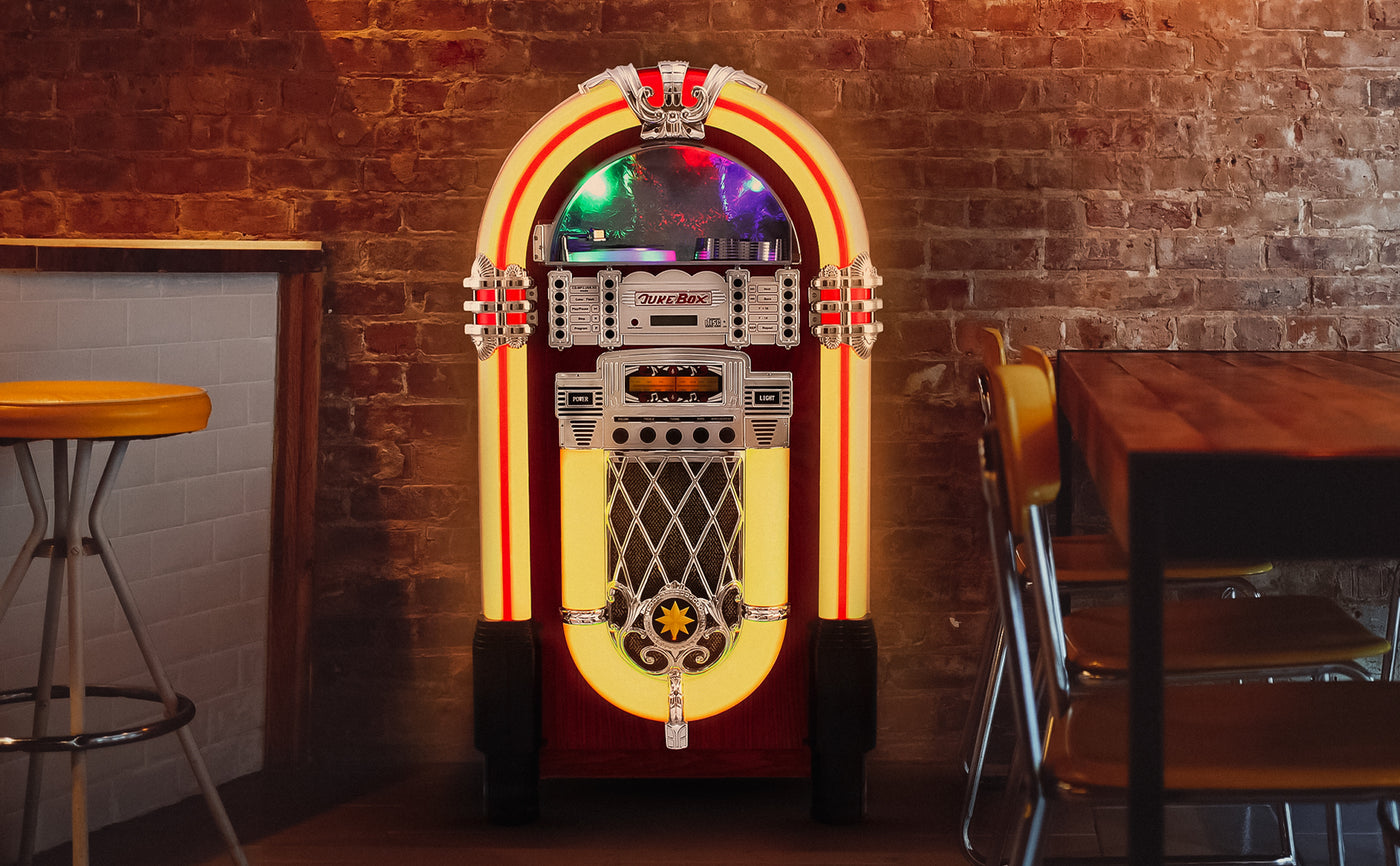 Jukebox vintage aux couleurs vives, avec des lumières néon, un design rétro et une finition en métal brillant sur fond de briques exposées