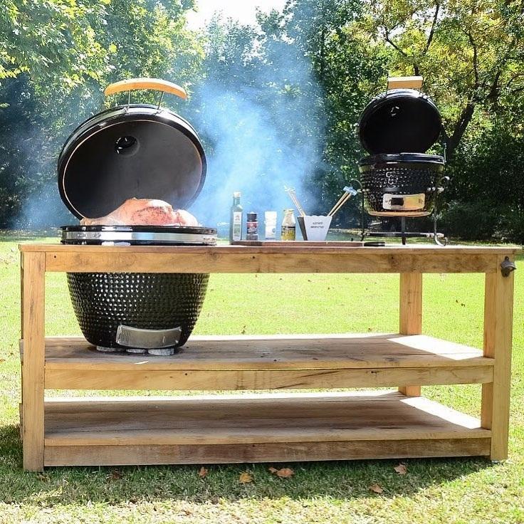 Barbecue au charbon de bois Kamado de 53,3 cm, en céramique noire, avec fumée, sur un support en bois rustique en plein air