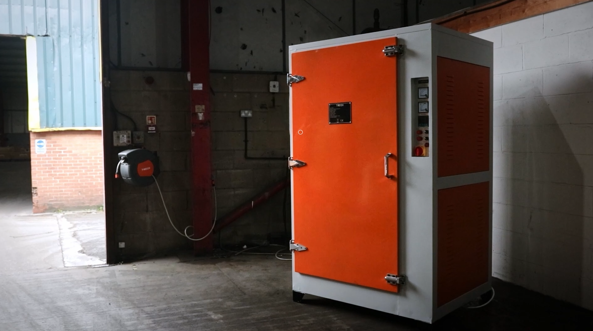 Armoire de stockage orange et blanche, avec des poignées métalliques, située dans un environnement industriel, murs en béton brut