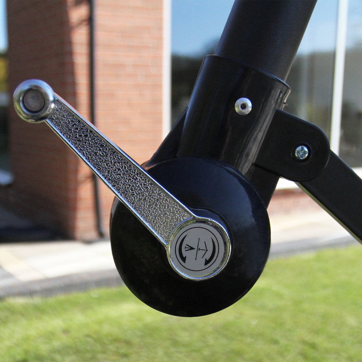 Mécanisme de réglage en métal brillant sur un parasol déporté noir de 3 m, avec une texture lisse et des détails élégants