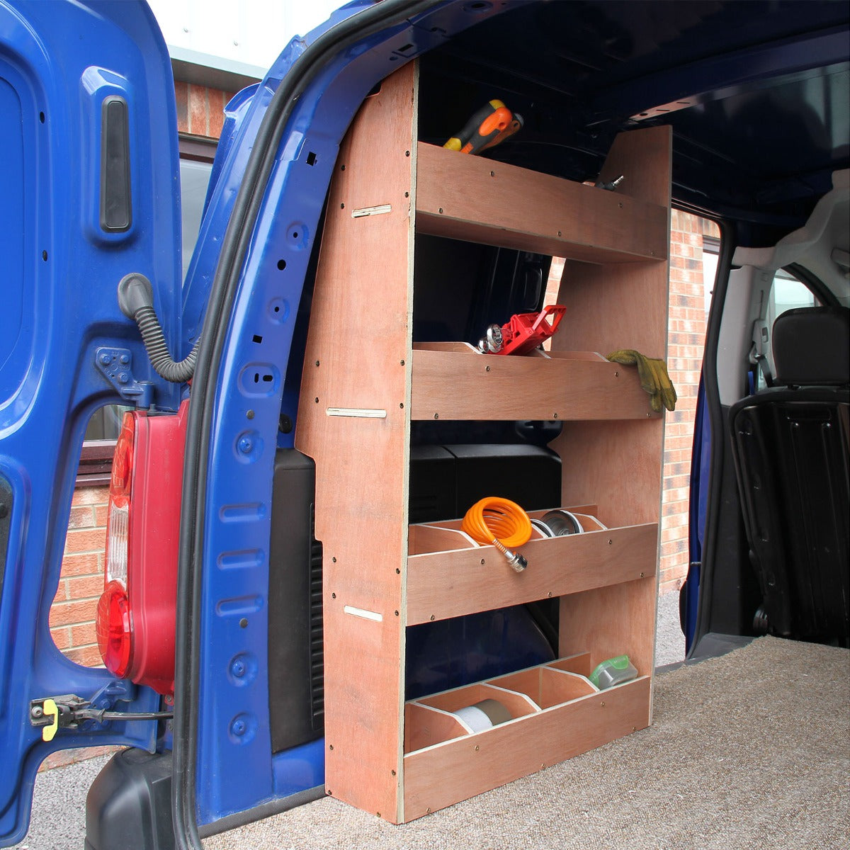 Rangement en MDF avec étagères en bois clair, installé à l'arrière d'un Berlingo, offrant une solution pratique pour l'organisation