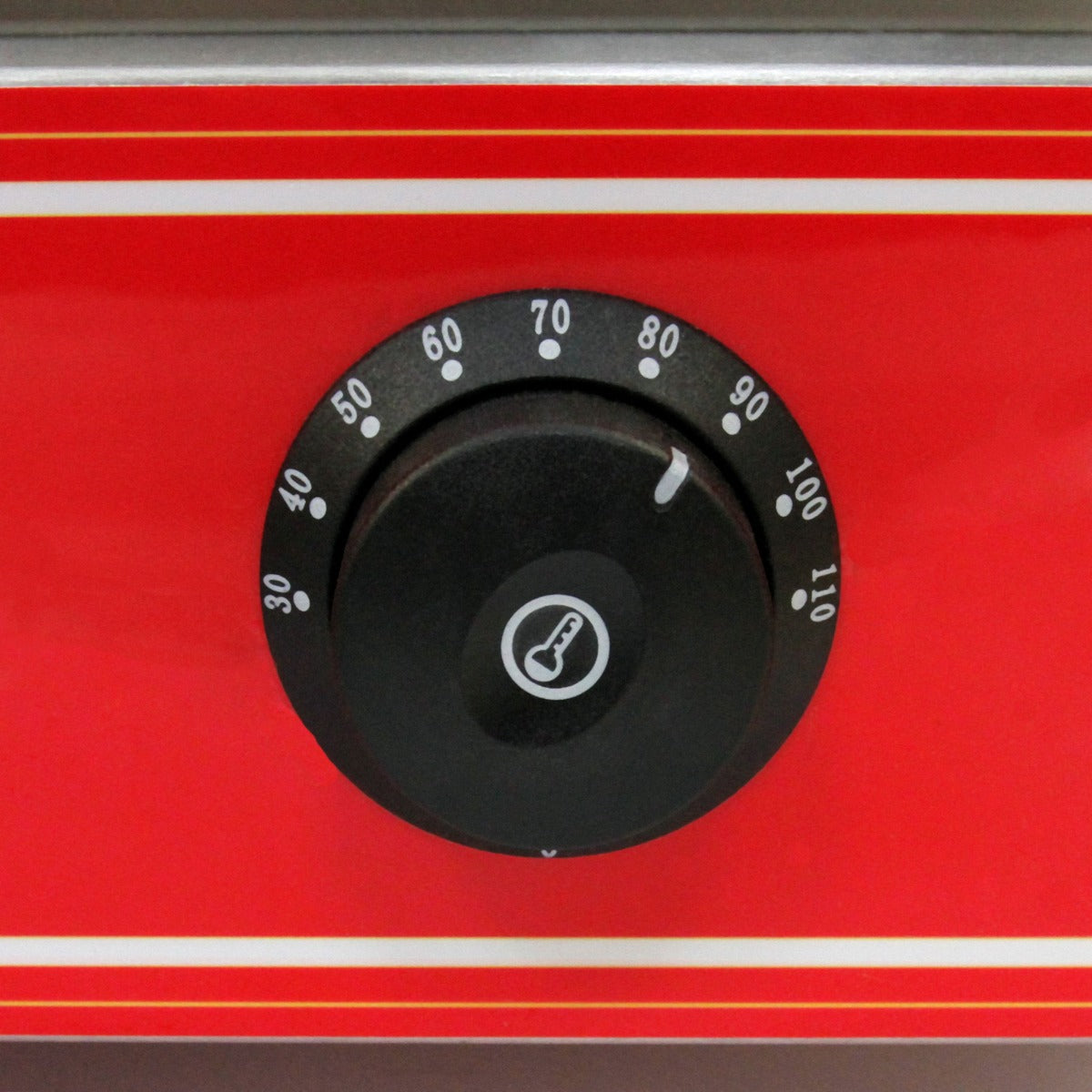 Bouton noir de réglage de température sur un cuiseur vapeur commercial KuKoo, avec un fond rouge et des graduations blanches