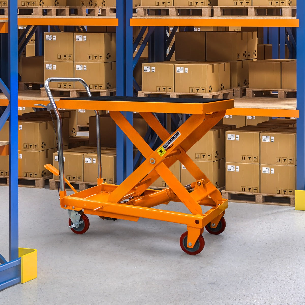 Table élévatrice hydraulique orange de 500 kg, avec roulettes, placée dans un entrepôt rempli de cartons empilés