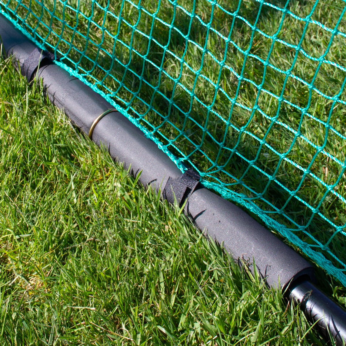 Cage d'entraînement de golf avec filet en maille verte, barres noires en plastique et support sur gazon vert, idéal pour la pratique