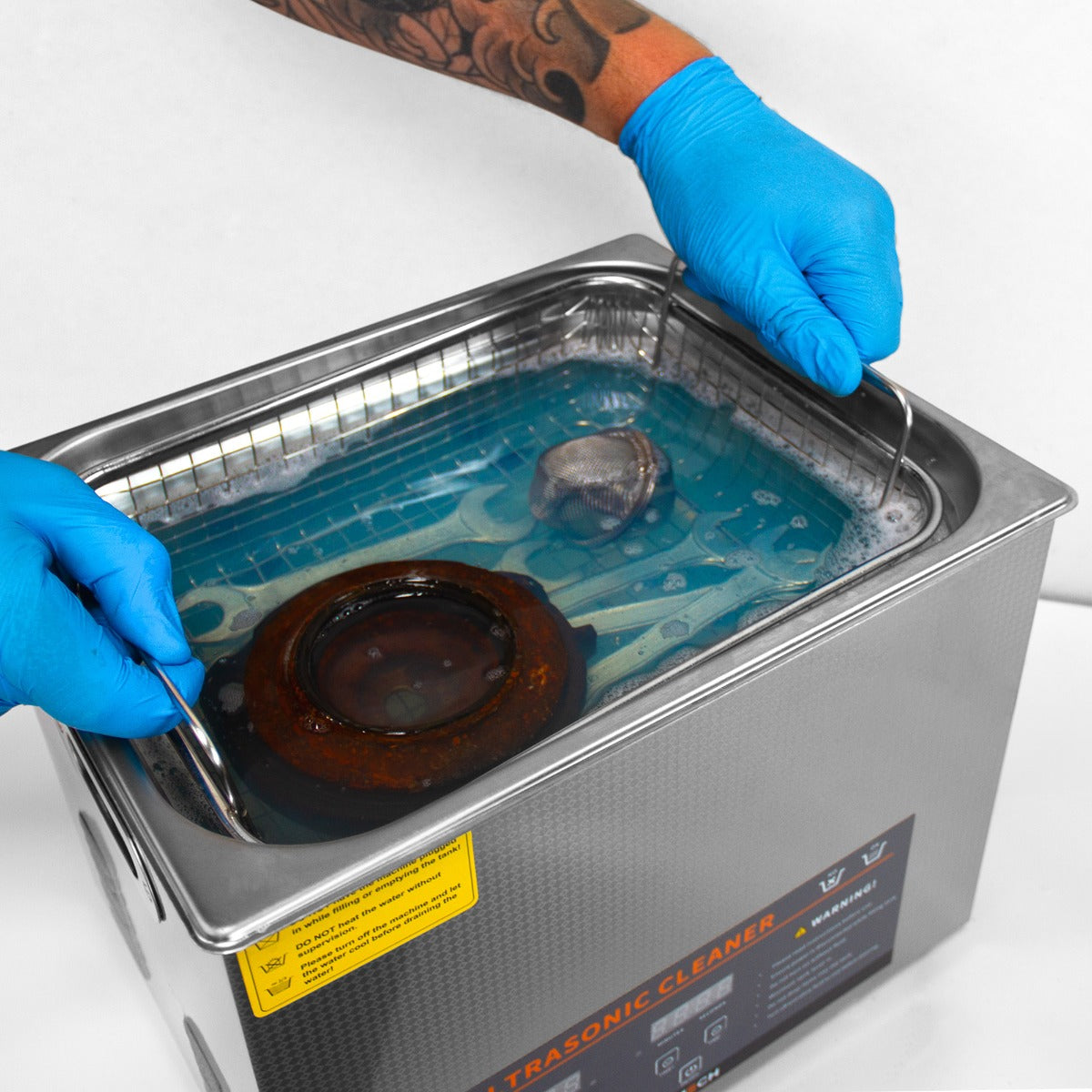 Nettoyeur ultrasonique T-Mech de 15 L avec un couvercle en acier inoxydable, eau bleue, et des pièces à nettoyer immergées