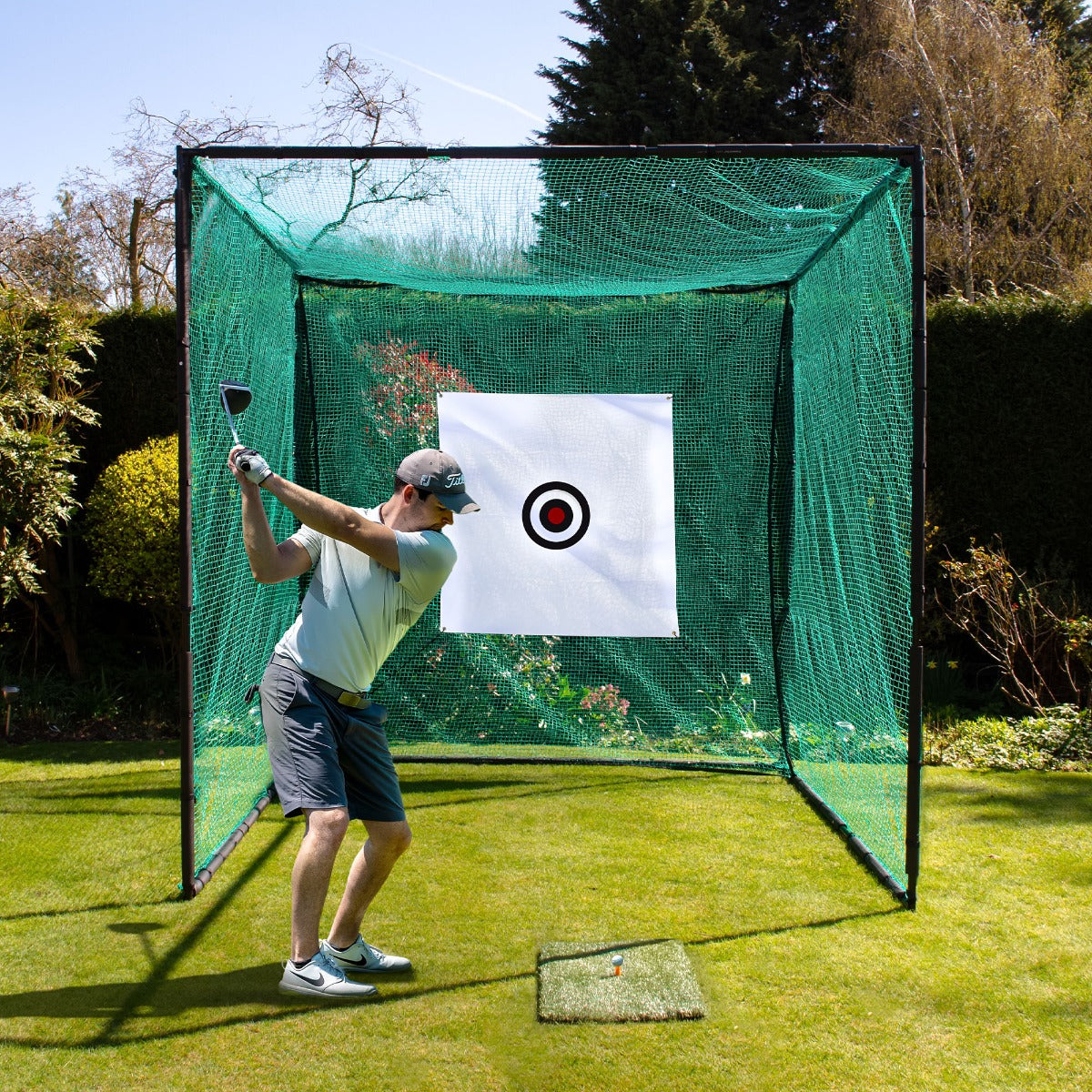 Cage d'entraînement de golf en filet vert avec cible à plusieurs trous, sur pelouse, joueur en action avec un club de golf