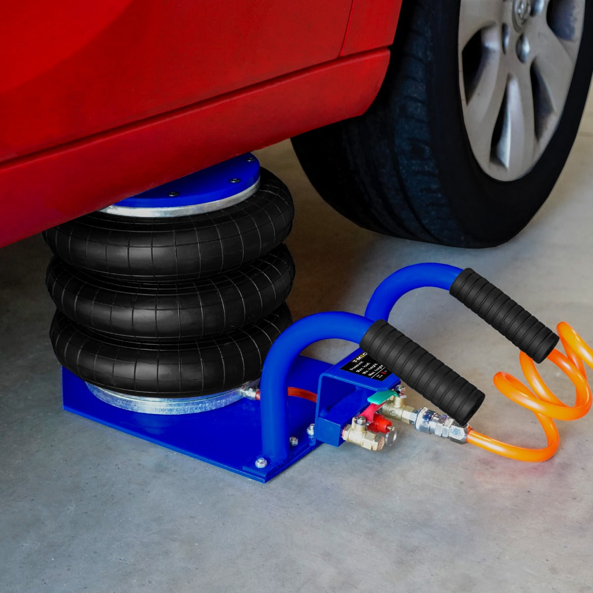 Cric pneumatique 3,5 T avec trois sacs en caoutchouc noir, tuyaux bleus et orange, sur une surface en béton sous une voiture rouge