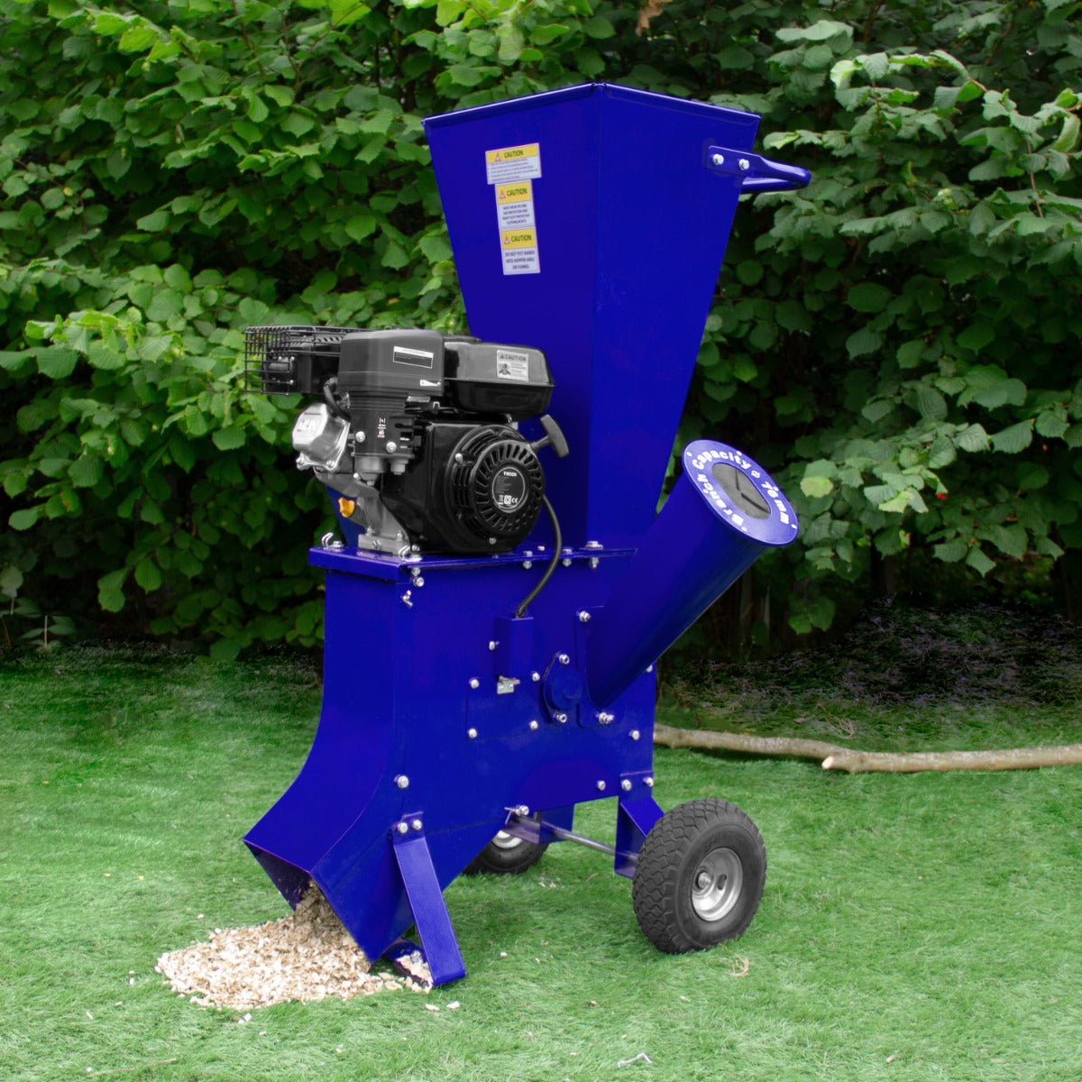 Déchiqueteuse de bois 7CV en métal bleu vif avec moteur noir, roues robustes et goulotte pour débris sur fond de verdure