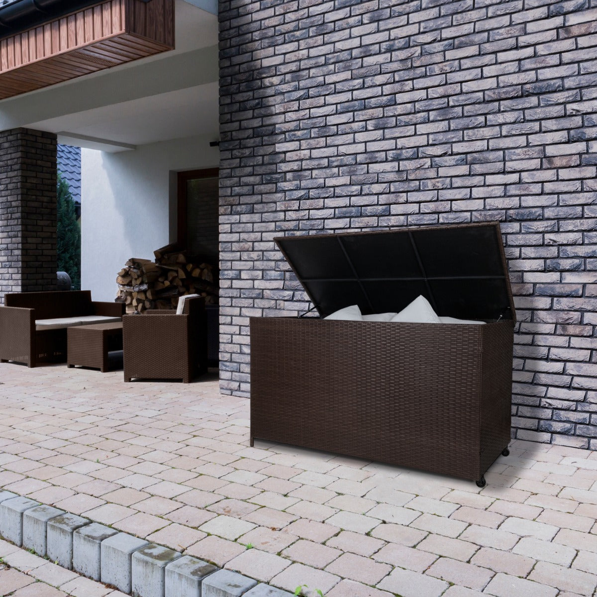 Coffre de rangement d'extérieur en rotin marron, 582 L, avec couvercle ouvert, placé sur un patio en pavés près d'un mur en briques