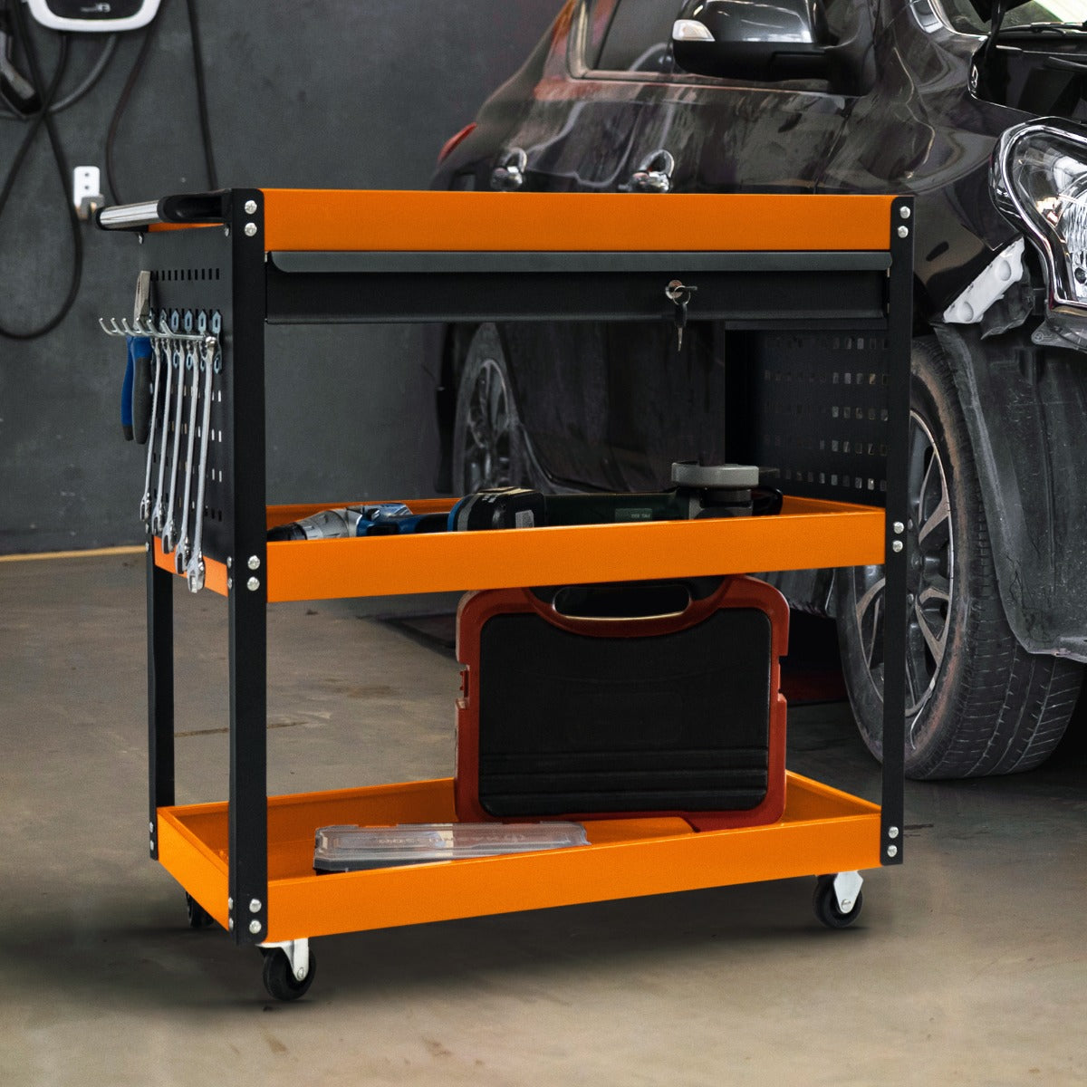 Chariot à outils sur roulettes noir et orange, avec étagères ouvertes, outils suspendus et boîte à outils en bas, idéal pour garage