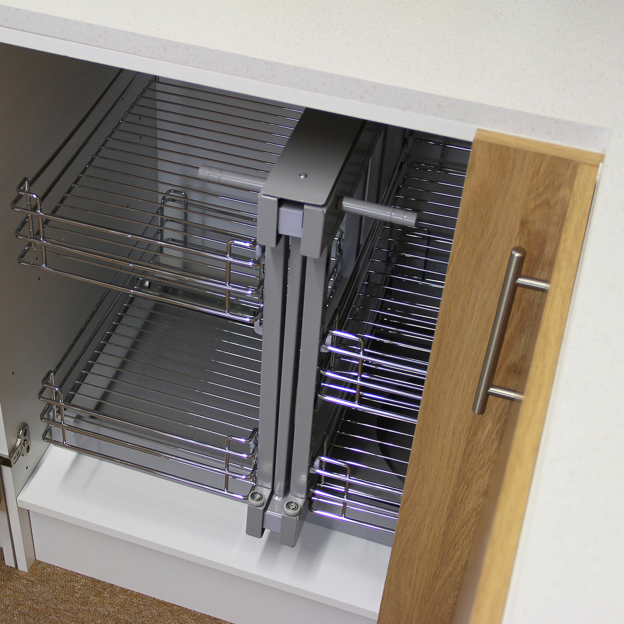 Paniers coulissants métalliques d’angle, finition argentée et bois clair, offrant un rangement pratique et accessible dans un meuble de cuisine