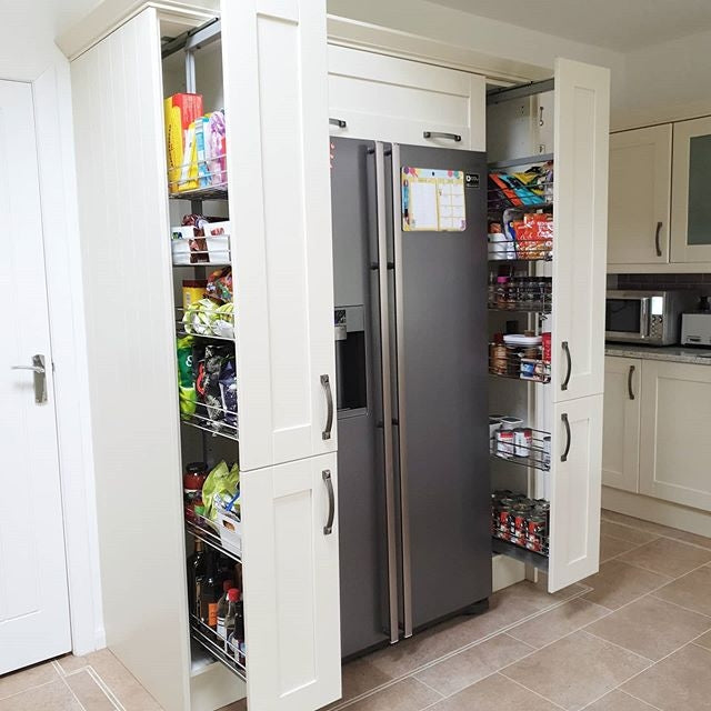 Garde-manger à fermeture amortie en bois blanc, portes ouvertes, étagères remplies de produits alimentaires et épices, design moderne