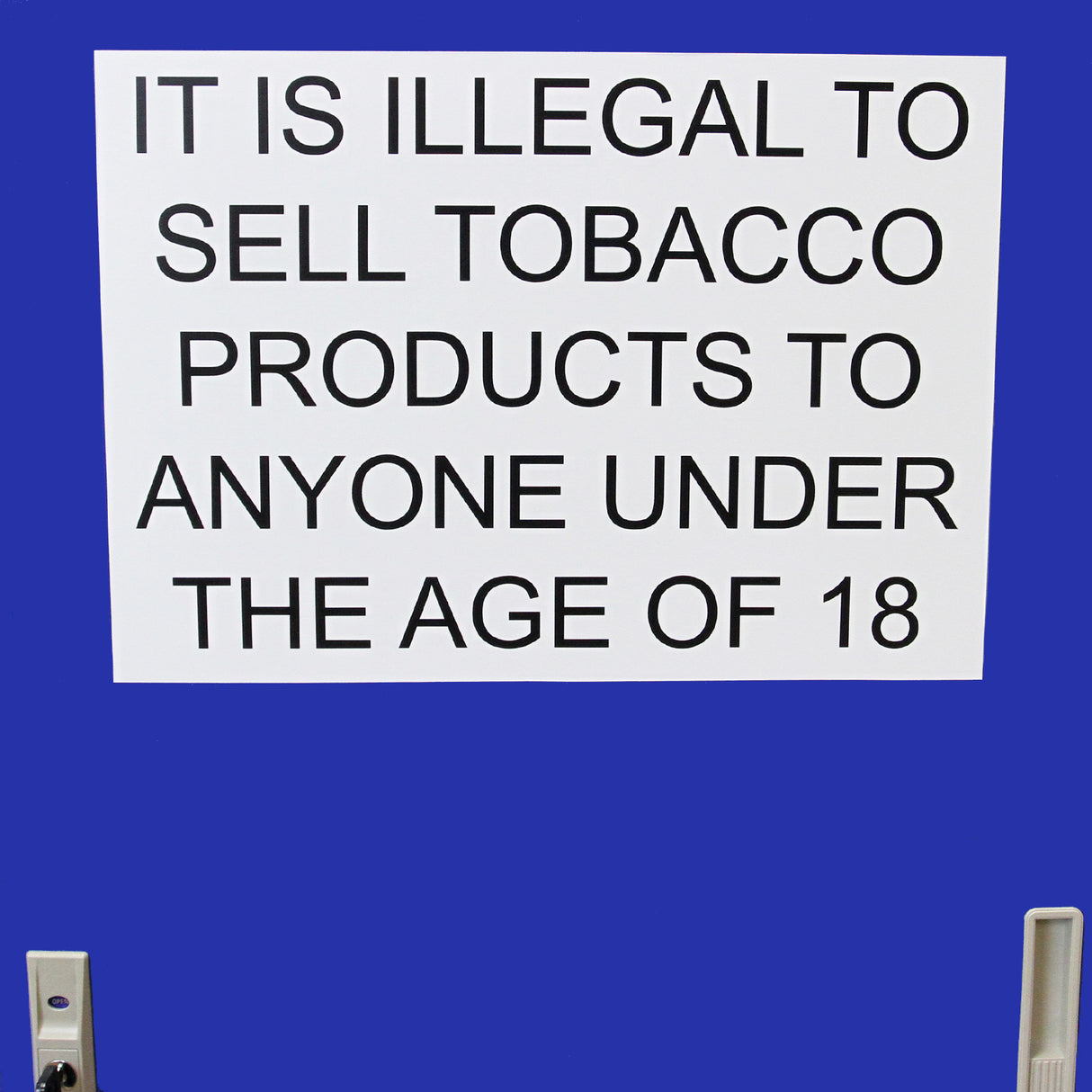Panneau blanc avec texte noir indiquant l'interdiction de vendre des produits du tabac aux moins de 18 ans, sur fond bleu