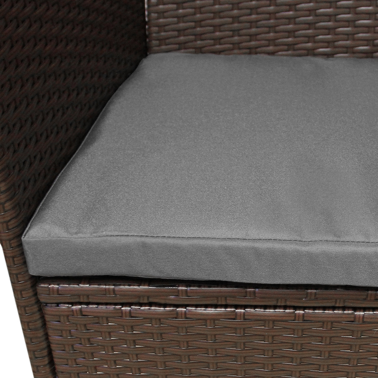 Coussin gris moelleux sur un fauteuil en rotin marron tressé, idéal pour un coin bistro extérieur confortable et élégant