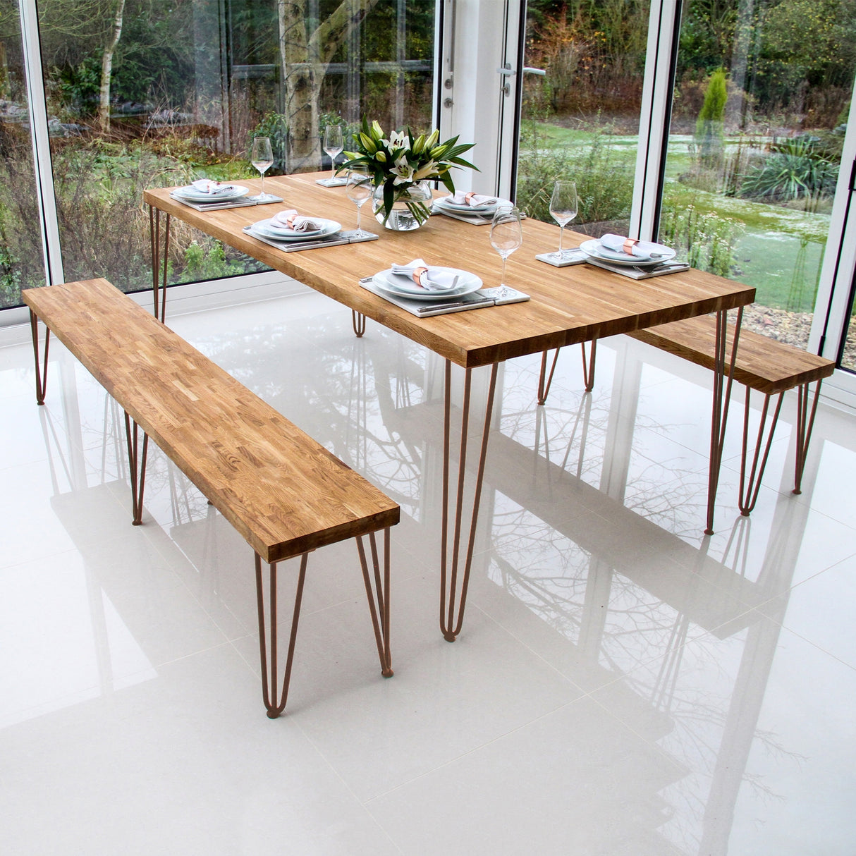 Quatre pieds de table en cuivre de 71 cm, avec tiges de 12 mm, soutenant un plateau en bois clair dans un cadre moderne et lumineux