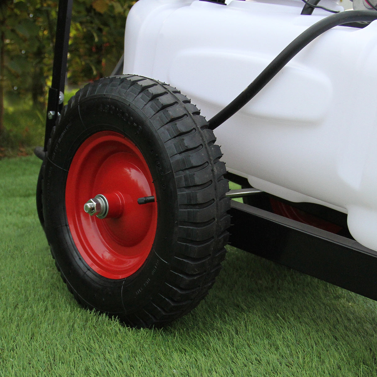 Pulvérisateur pour quad de 100L avec remorque, réservoir blanc, roues noires et rouges, conçu pour une utilisation sur terrain varié