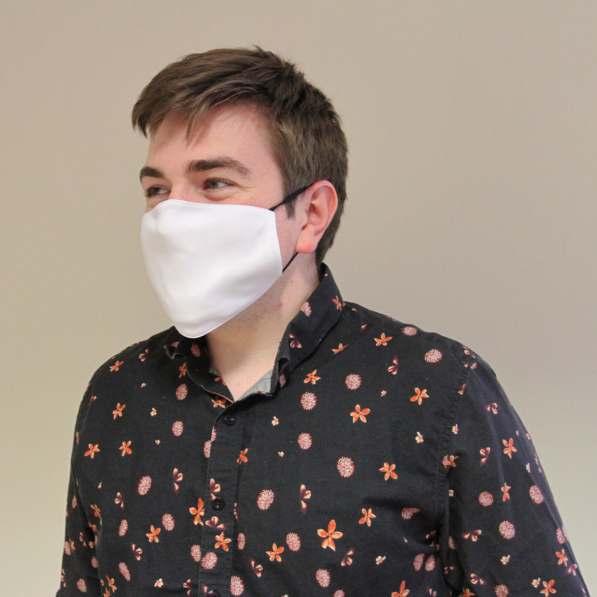 Masque de visage vierge en tissu blanc, ajusté, porté par un homme en chemise à motifs, idéal pour la sublimation personnalisée