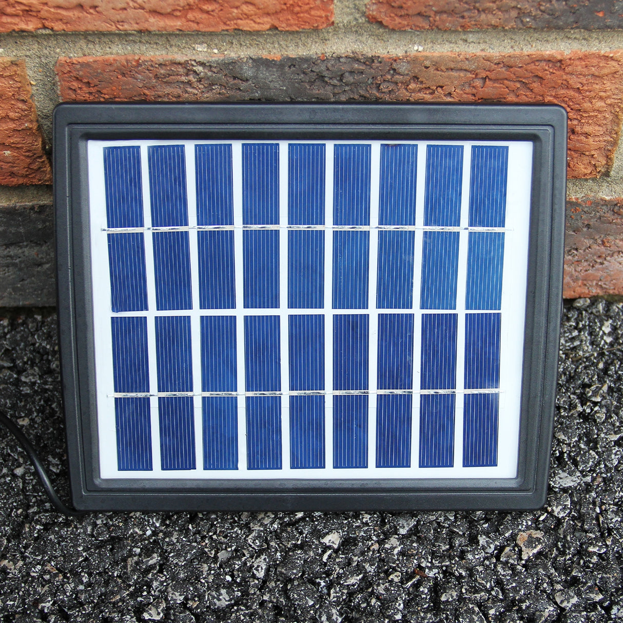 Panneau solaire noir avec cellules photovoltaïques bleues, conçu pour alimenter une fontaine de jardin à 4 niveaux en extérieur