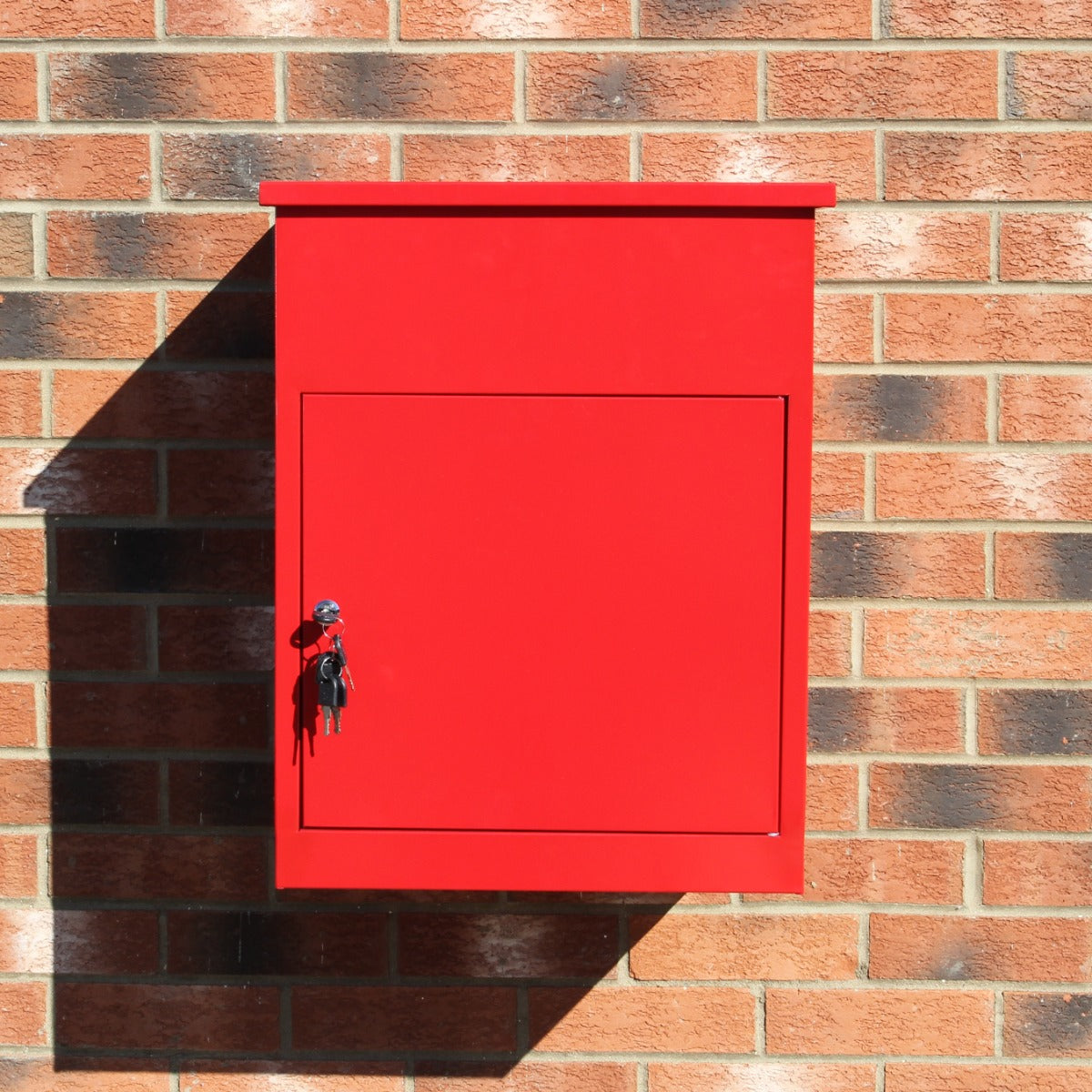 Boîte à colis rouge brillante fixée à un mur en briques, avec une serrure et un design moderne et épuré, idéale pour la livraison sécurisée