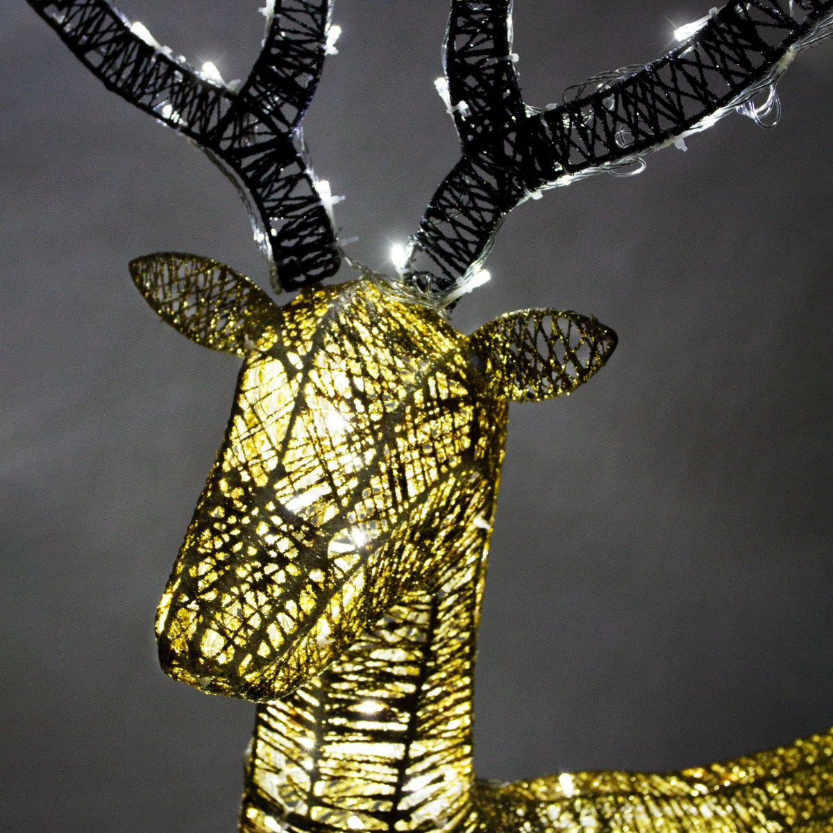 Cerf doré décoratif avec des lumières LED blanches chaudes, présentant un design en fil métallique et une texture brillante