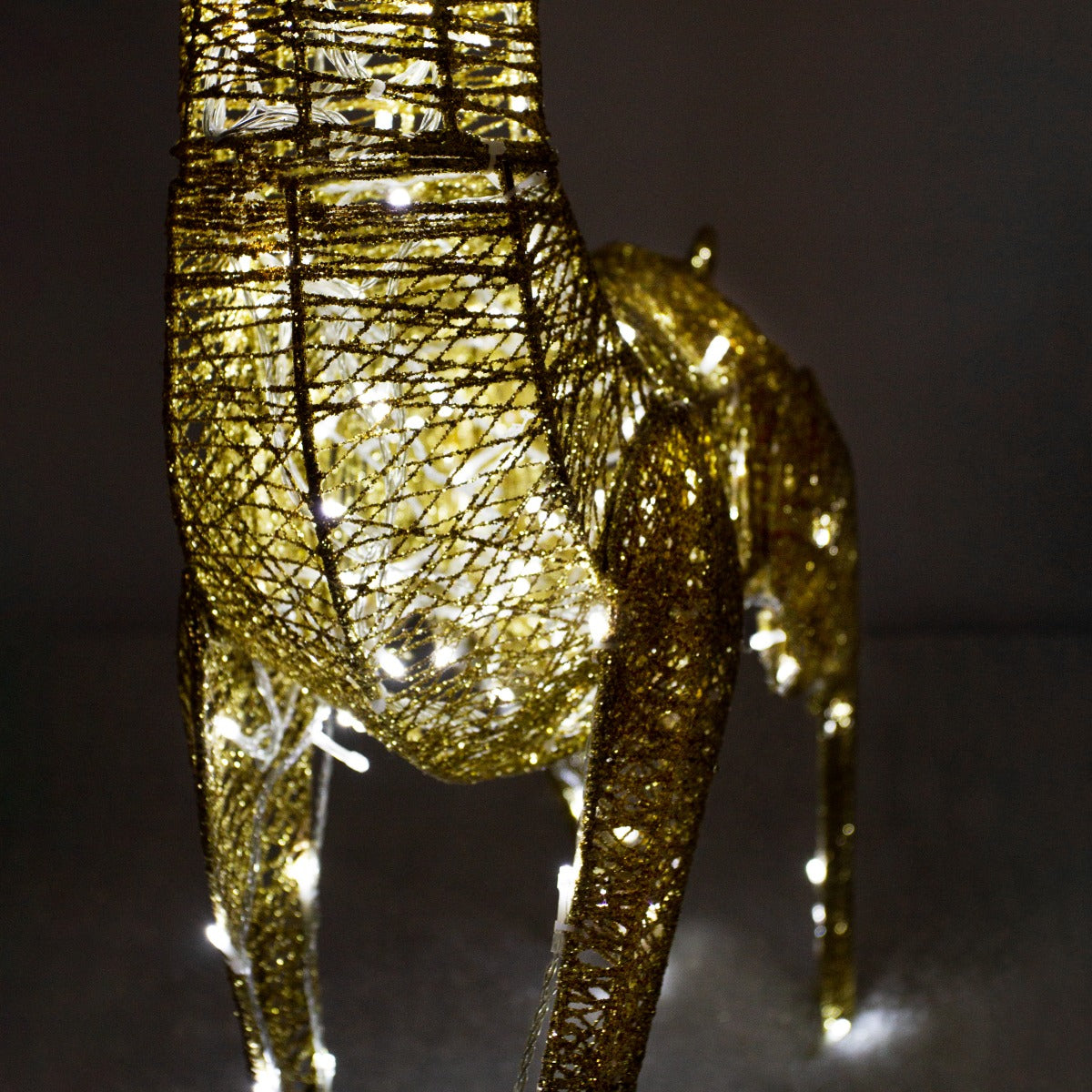 Cerf doré en métal avec éclairage LED blanc chaud, affichant une texture tissée et un design élégant pour une décoration festive