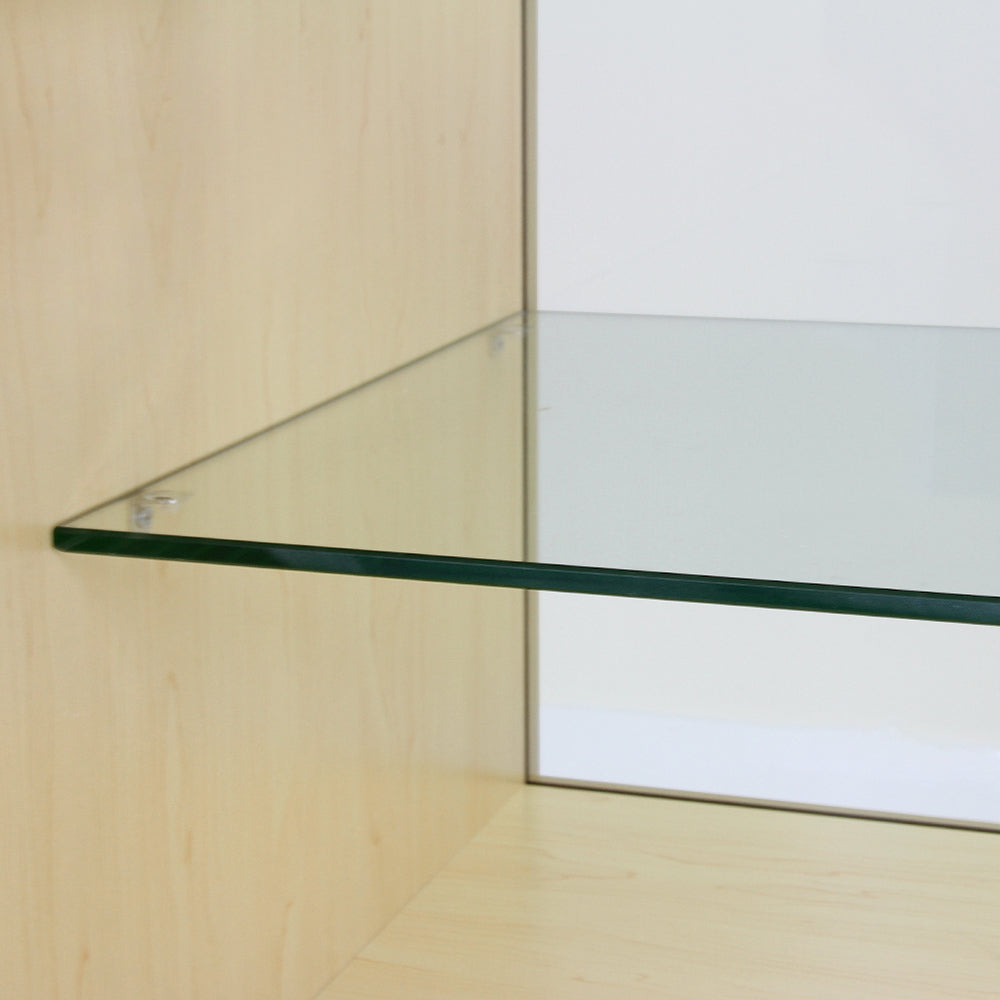 Étagère en verre transparent sur un fond en érable clair, avec des bords polis et des fixations discrètes, idéale pour une présentation élégante