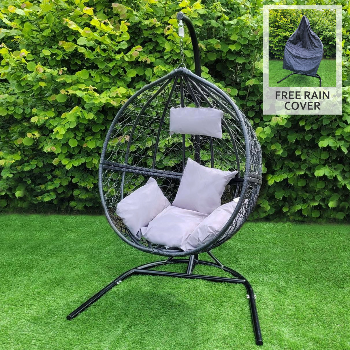 Chaise suspendue en rodin noir en forme de goutte, avec coussins gris clair, sur un support en métal, entourée de verdure
