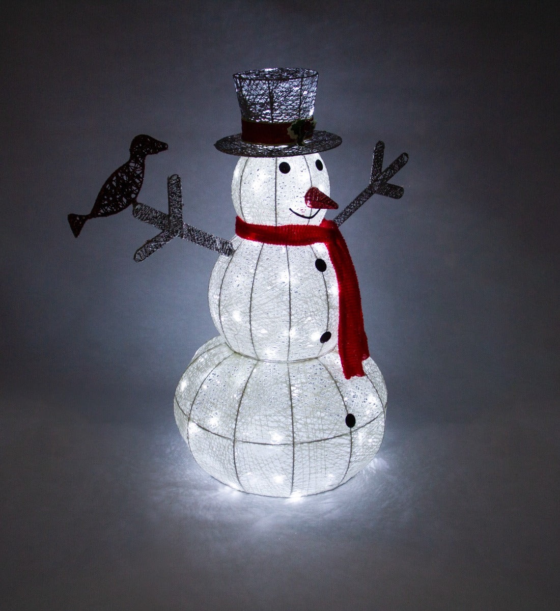 Bonhomme de neige lumineux en forme de boule, avec un chapeau noir, écharpe rouge, et un oiseau décoratif, émettant une lumière blanche froide