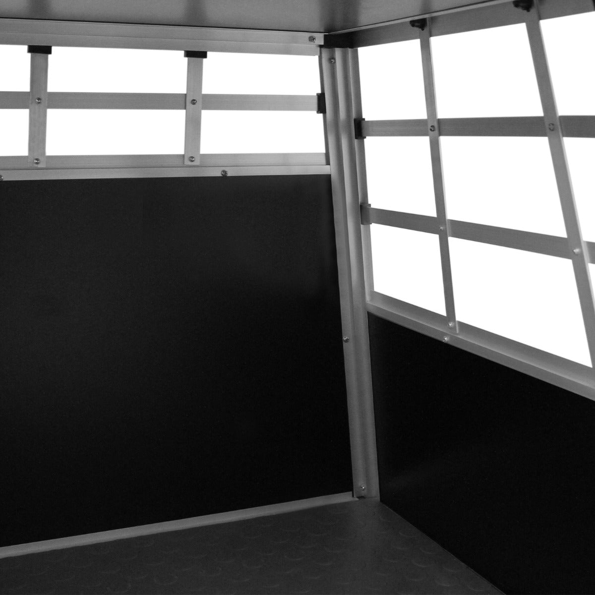 Cage de transport pour animaux petit format, en métal argenté avec des parois noires et des grilles pour ventilation, intérieur spacieux et sécurisé