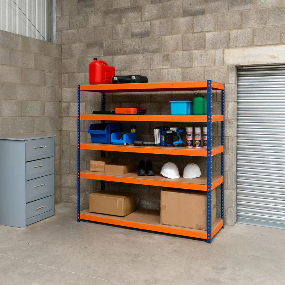 Étagère en métal orange avec plusieurs niveaux, contenant des boîtes en carton, des outils, des casques et des bouteilles, sur fond de mur en béton gris