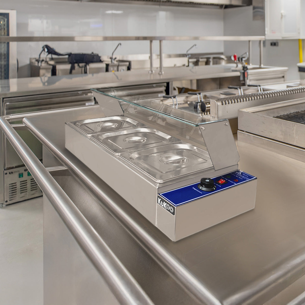 Bain Marie KuKoo à 3 bacs en inox, avec couvercle en verre, surface lisse et boutons de contrôle bleus, idéal pour les cuisines professionnelles